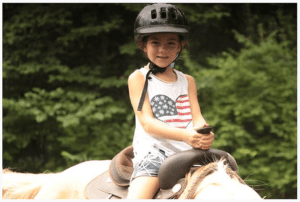 Kathrynn Hudson rides a horse at her first week-long summer camp for military kids at YMCA's Camp Carson back in 2013. 