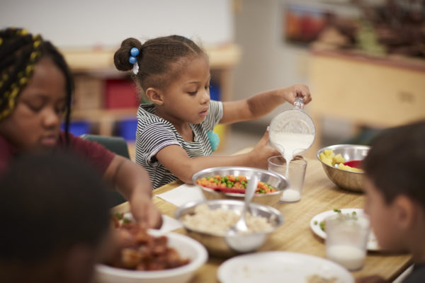 KinderCare classroom with child and healthy eating
