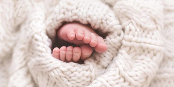 baby feet wrapped in sweater