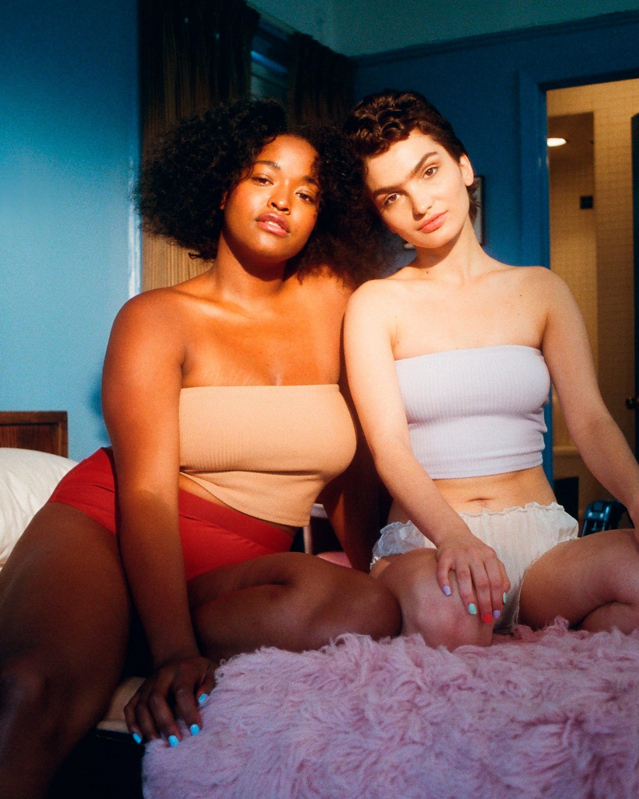 two women in swimwear sitting on bed promoting positive body image