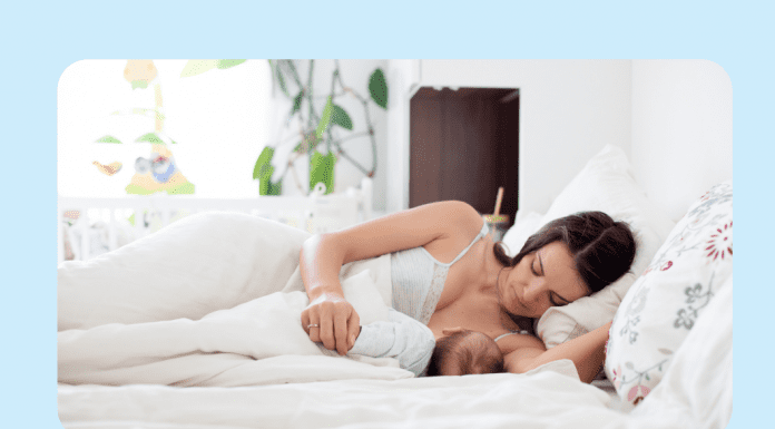 woman breastfeeding in bed on light blue background
