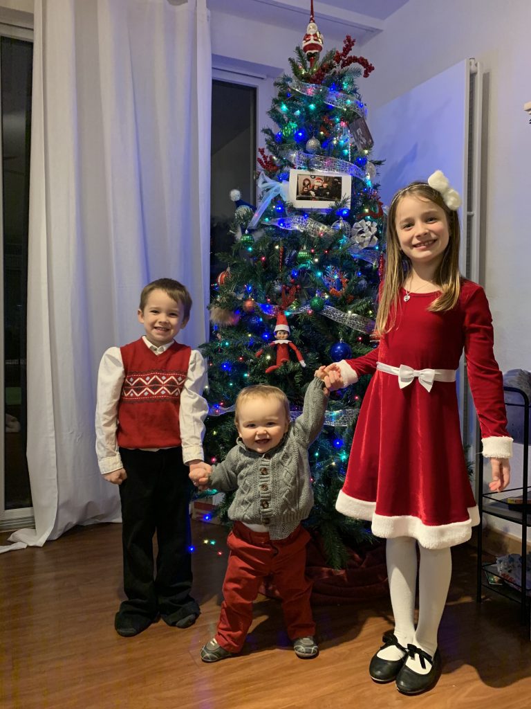 children in front of a christmas tree
