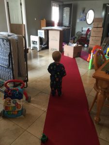 child standing around moving boxes