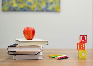 books, apple, pencils on desk