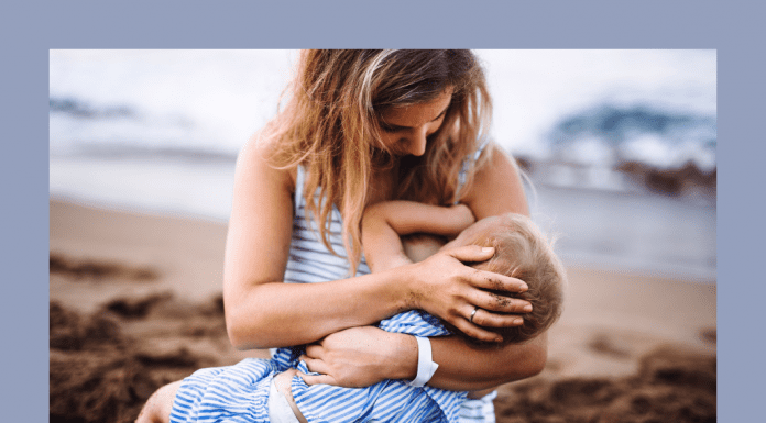 mother breastfeeding toddler on beach