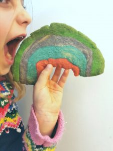 child eating a rainbow biscuit 