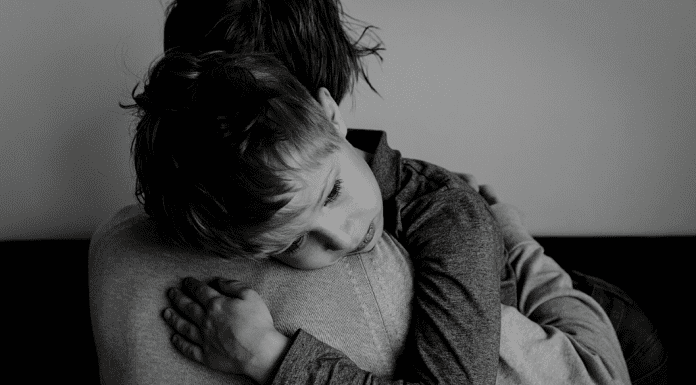 child hugging a parent in black and white