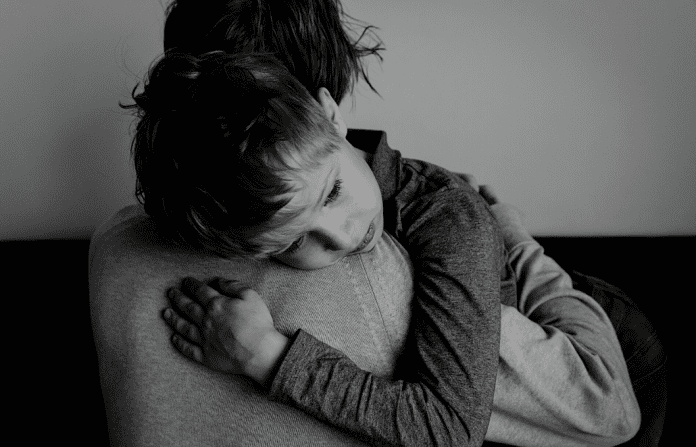 child hugging a parent in black and white