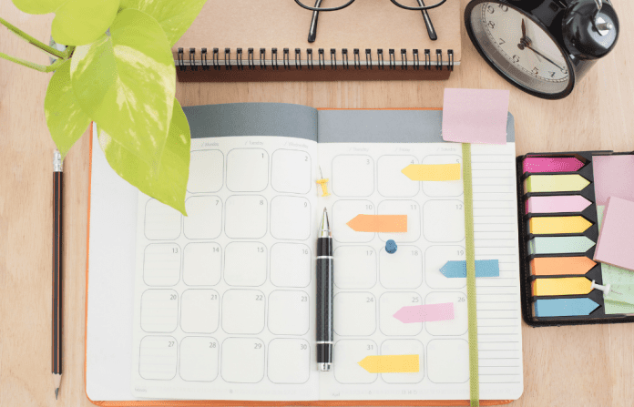 desktop with planner and notes and pens