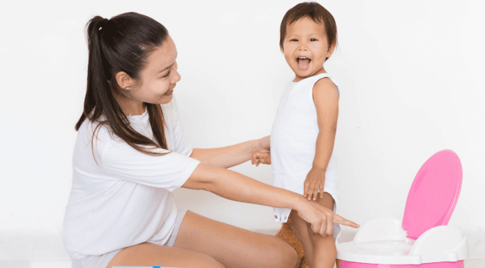 mom and toddler standing with a potty chair