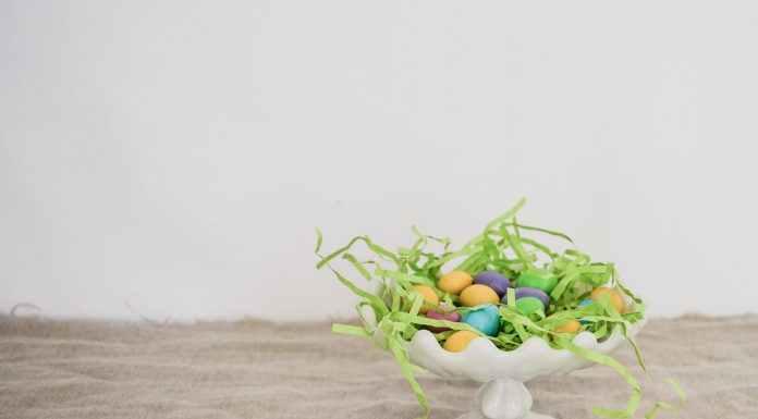 white platter with Easter grass and eggs on wood table