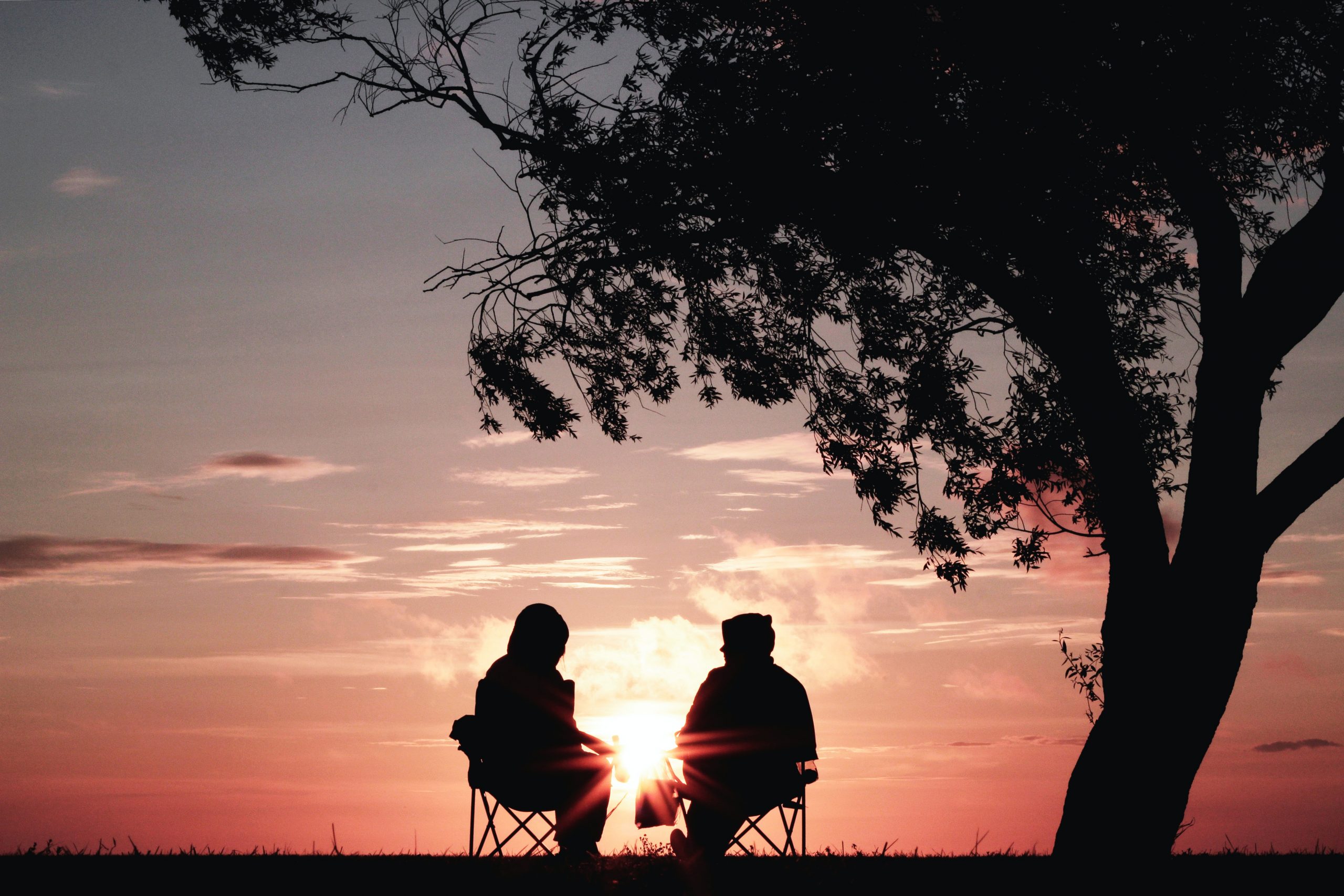 couple sitting together looking at the sunset