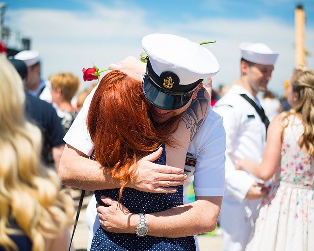 woman embracing her navy husband at a military homecoming