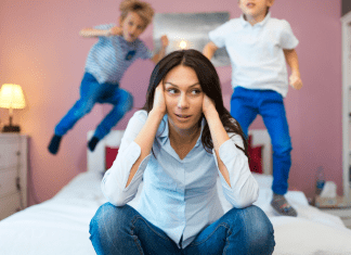 frustrated mother with kids jumping on the bed