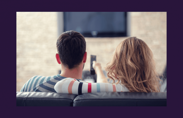 man and woman on couch watching TV