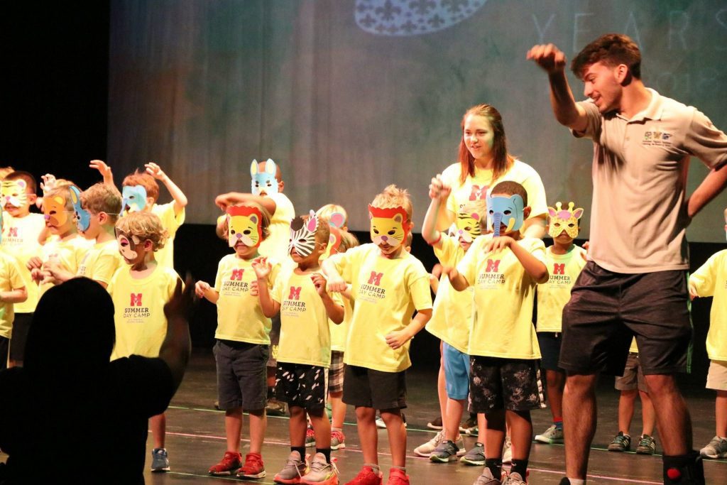 Students performing an animal dance with animal masks