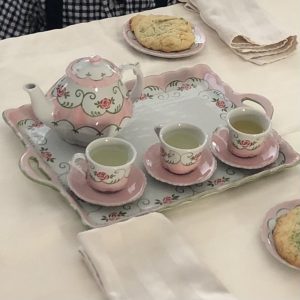 Miniature tea set: pink and white with green accents.