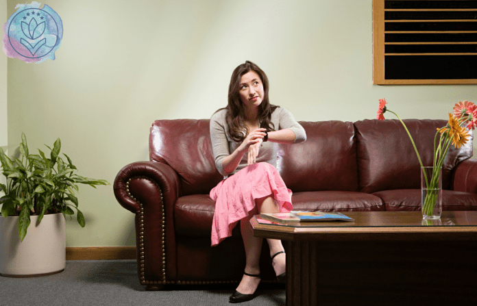 woman sitting on a couch looking at watch and waiting