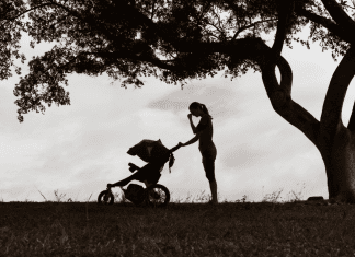 woman with a stroller outside in black and white