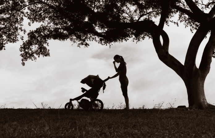 woman with a stroller outside in black and white