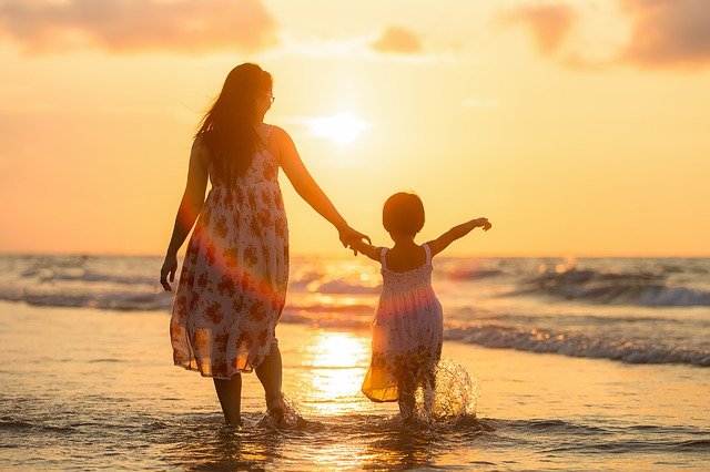 mother and daughter standing on the beach