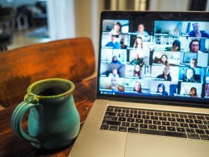 laptop with Zoom open in a video call with coffee cup