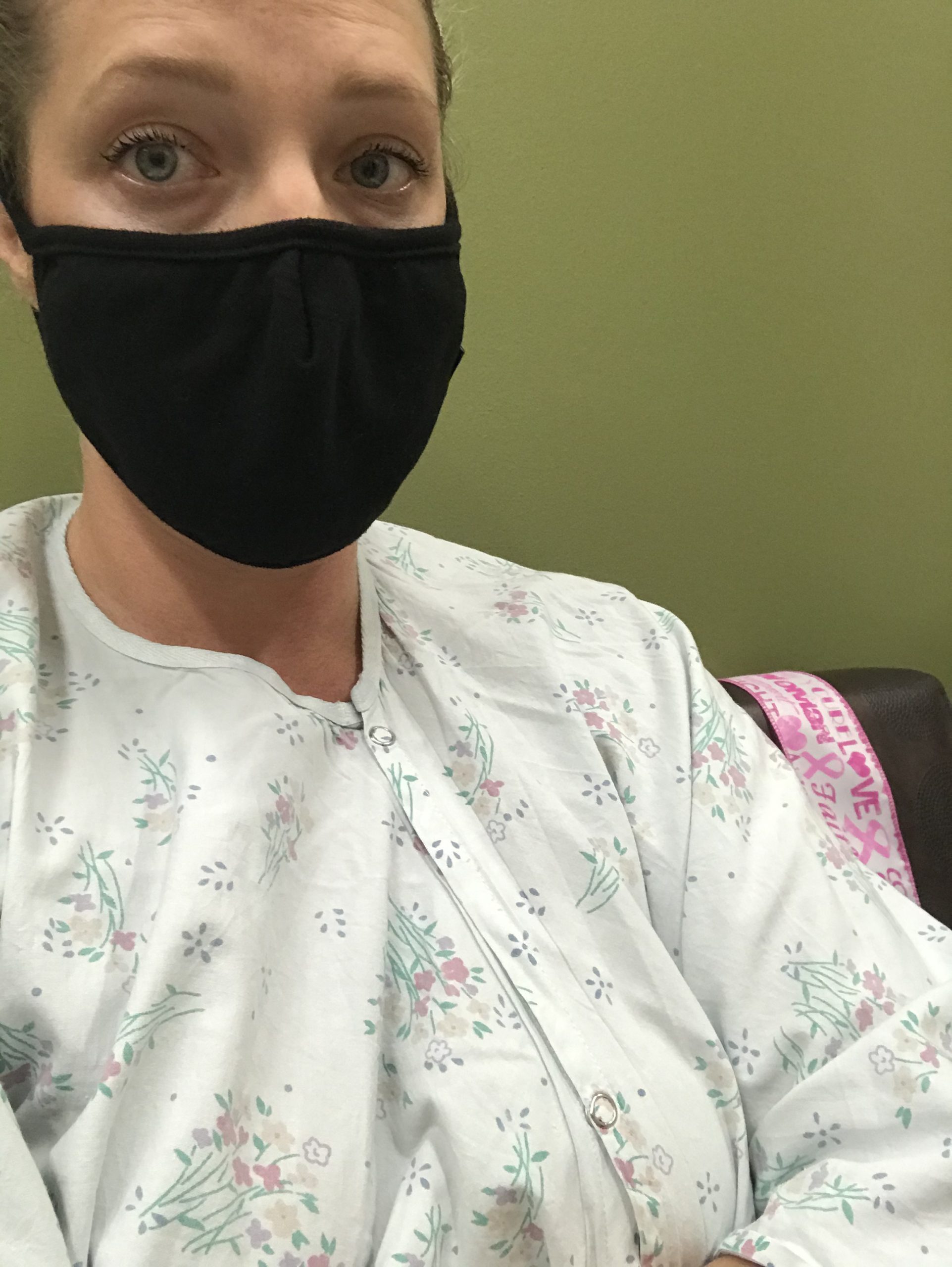 Samantha Persell with a mask and hospital gown for cancer treatment