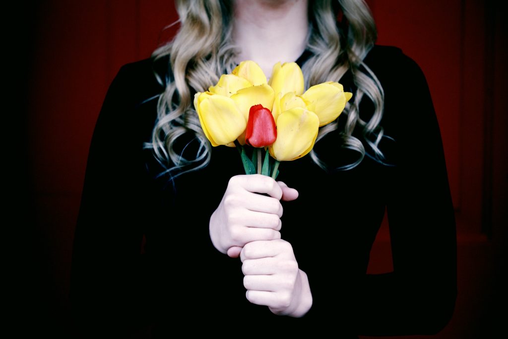 woman holding a bouquet of flowers in black to signify mourning