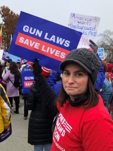 Alexandra holding a Gun Laws Save Lives sends at a demonstration at the supreme court