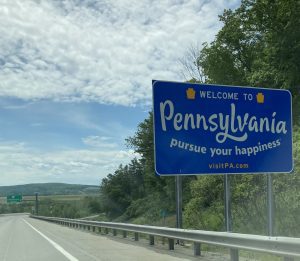 Welcome to Pennsylvania sign at the state line saying 'Welcome to Pennsylvania pursue your happiness'