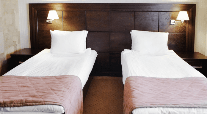 two beds in the same room with a dark wood headboard
