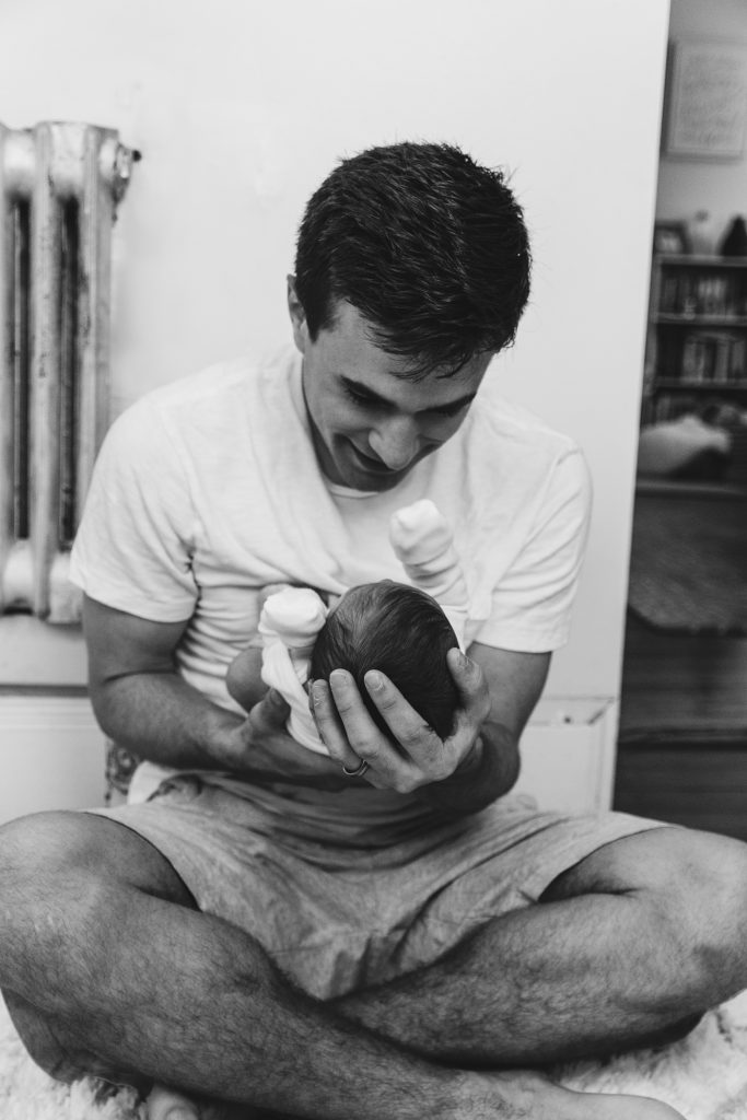 dad holding infant child in black and white