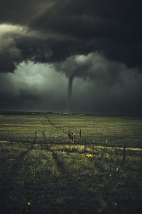 storm clouds and funnel in the background of an empty field