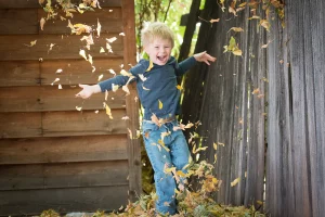 child jumping in leaves