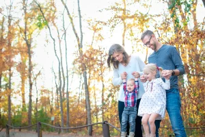 family with small children walking in fall trees