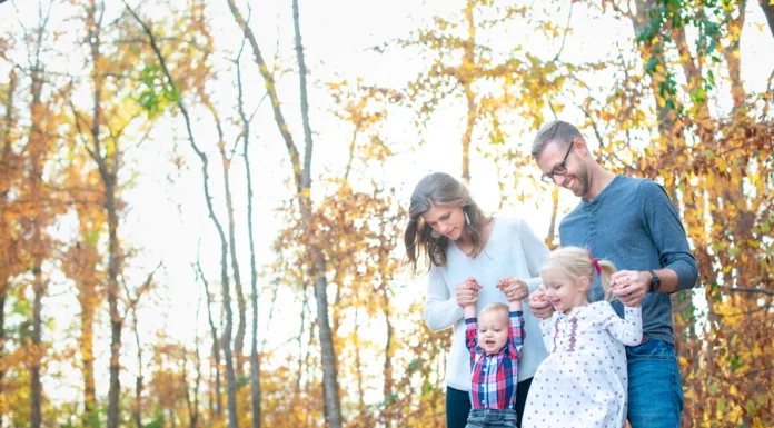 family with small children walking in fall trees