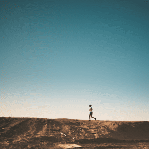 woman running on a dusty hillside at pace