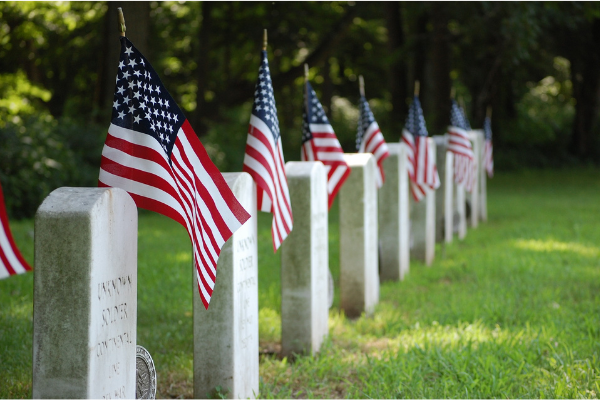 American flags on headstones at a cemetery