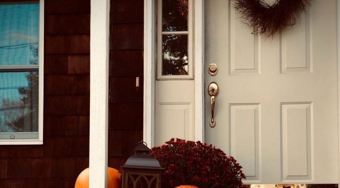 fall decor outside of a front door and porch