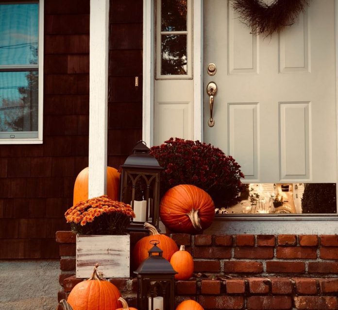fall decor outside of a front door and porch