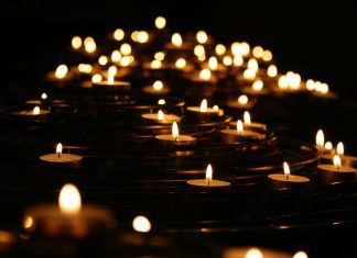 multiple lit votive candles to symbolize death or mourning