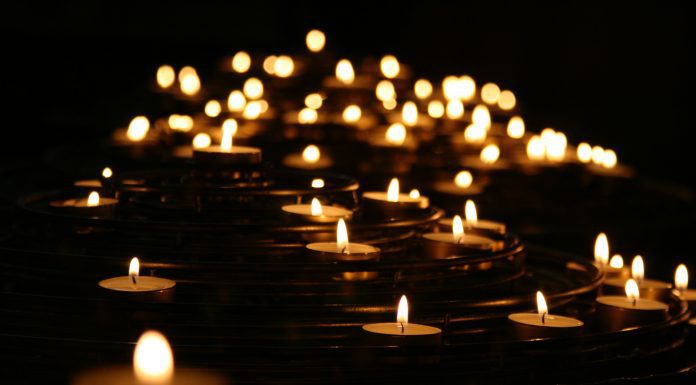 multiple lit votive candles to symbolize death or mourning