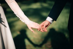 two people holding hands in wedding attire