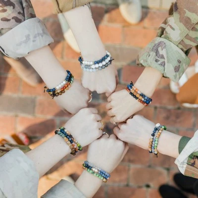 6 women wearing Charliemadison Originals bracelets with fists together