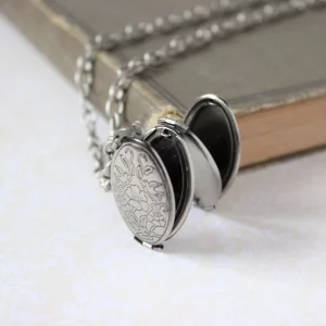 silver locket next to an old book