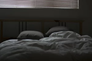 unmade bed in a darkened room