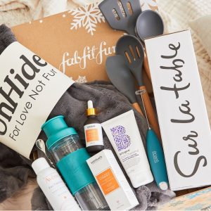 Assorted beauty and home products on a FabFitFun box with winter details