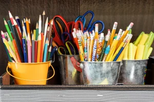 pencils, markers, and scissors in metal cups 