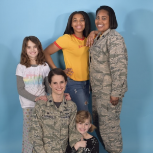 two women in military uniform with their three kids.