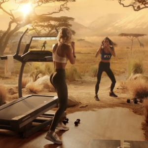 woman working out next to treadmill, with a desert background to feel that she's actually training in the desert.